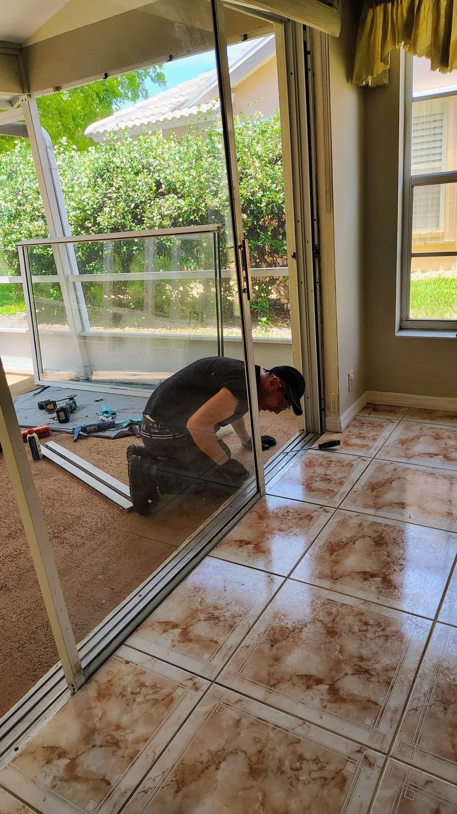 KayGE technician rebuilding a sliding door in a screened Florida patio room