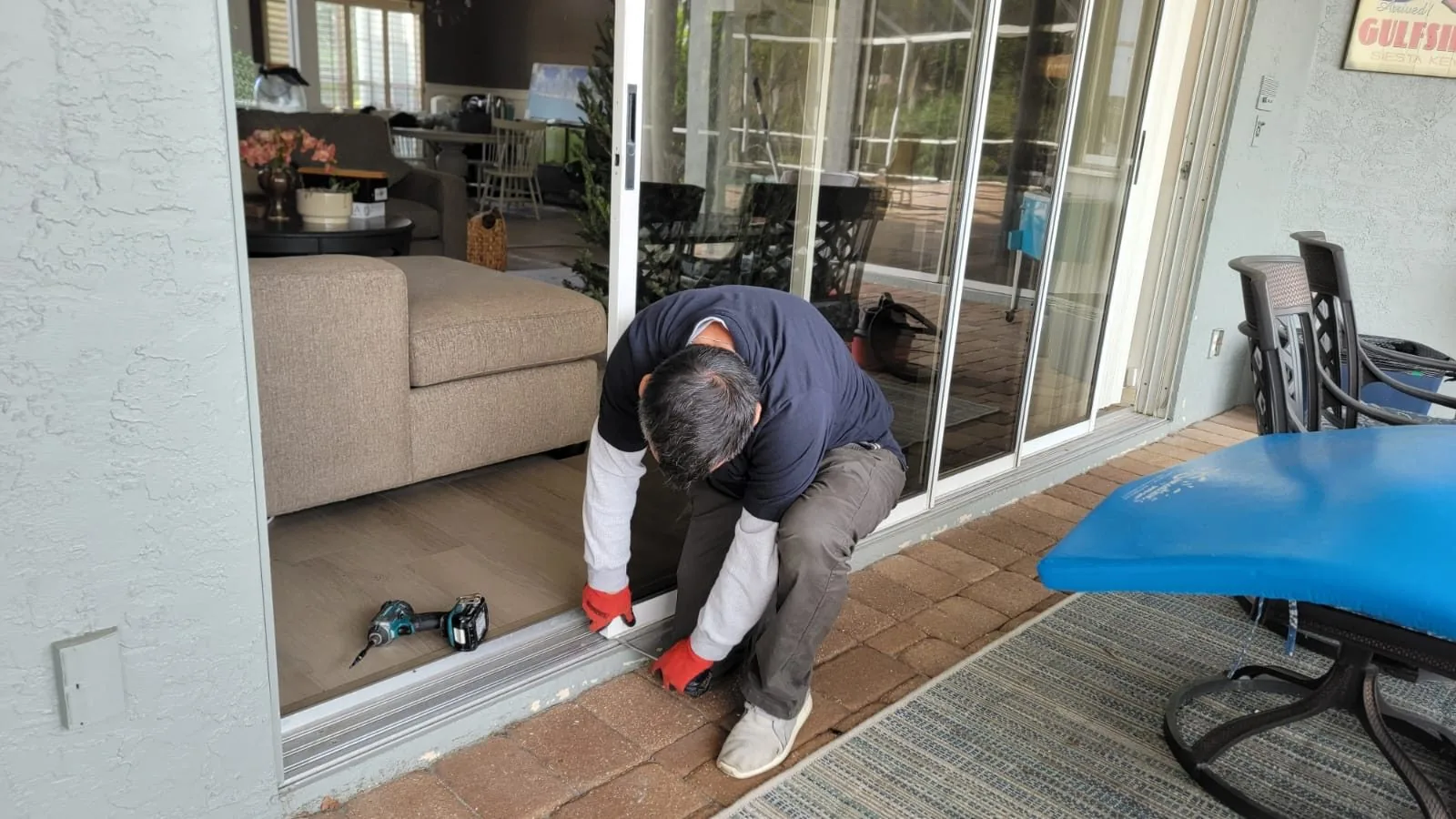 KayGE technician repairing a sliding door track at a Siesta Key home