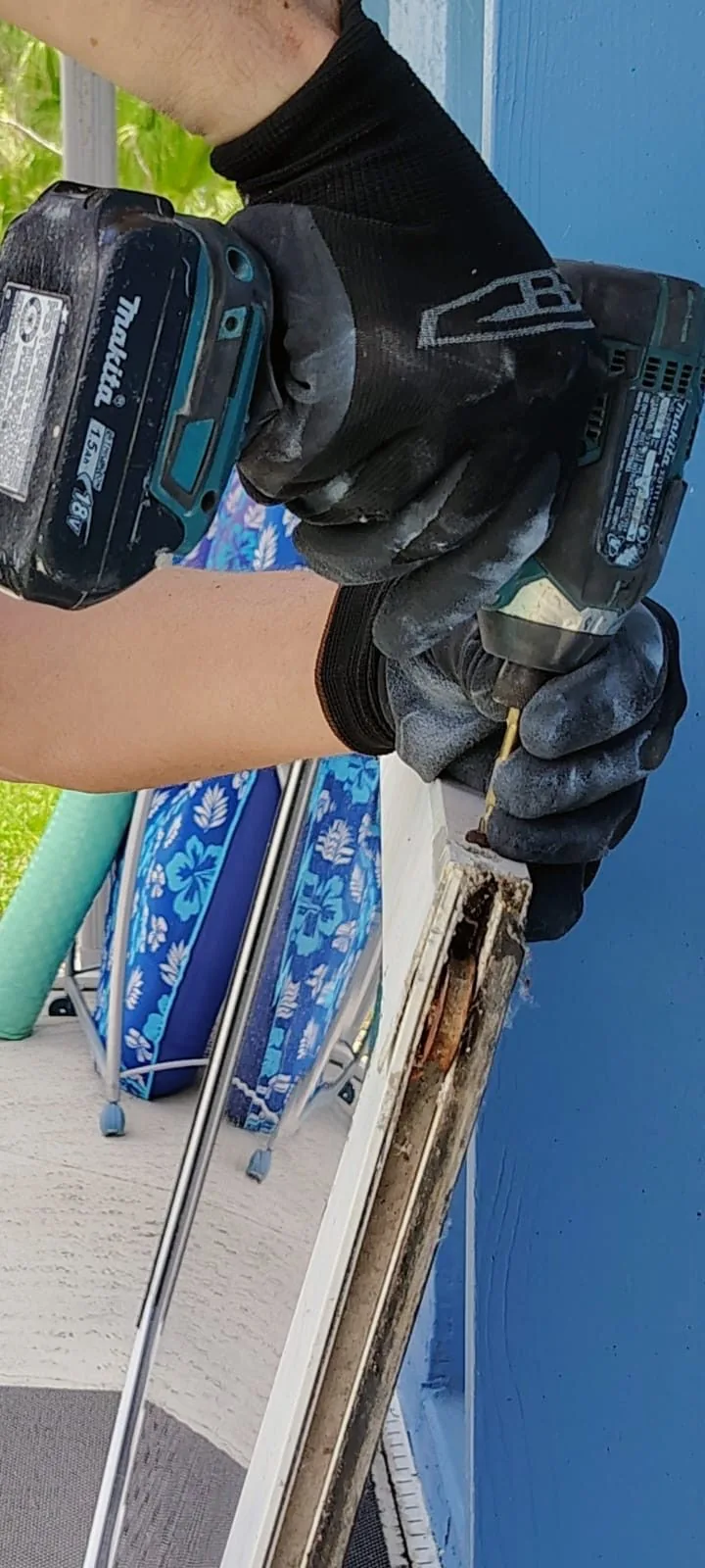 Close-up of KayGE technician replacing roller hardware at a sliding door corner