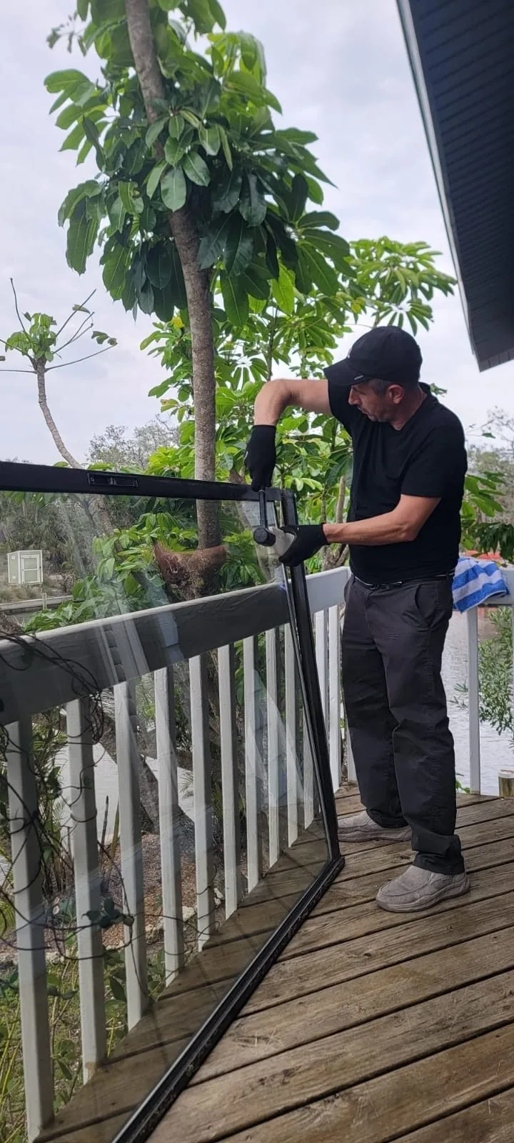 KayGE technician removing a sliding glass panel on a waterfront deck